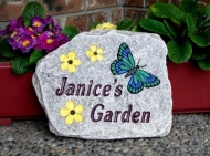 Yellow flowers in the green butterfly engraved on Genesis garden stone