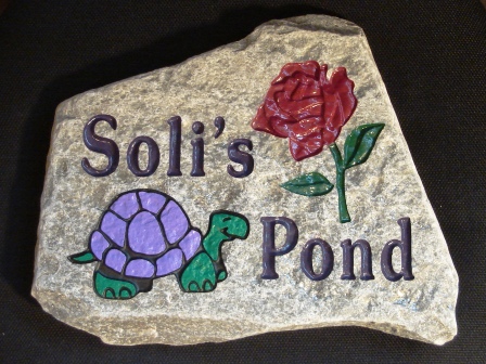 Garden stone engraved with a rose and a turtle